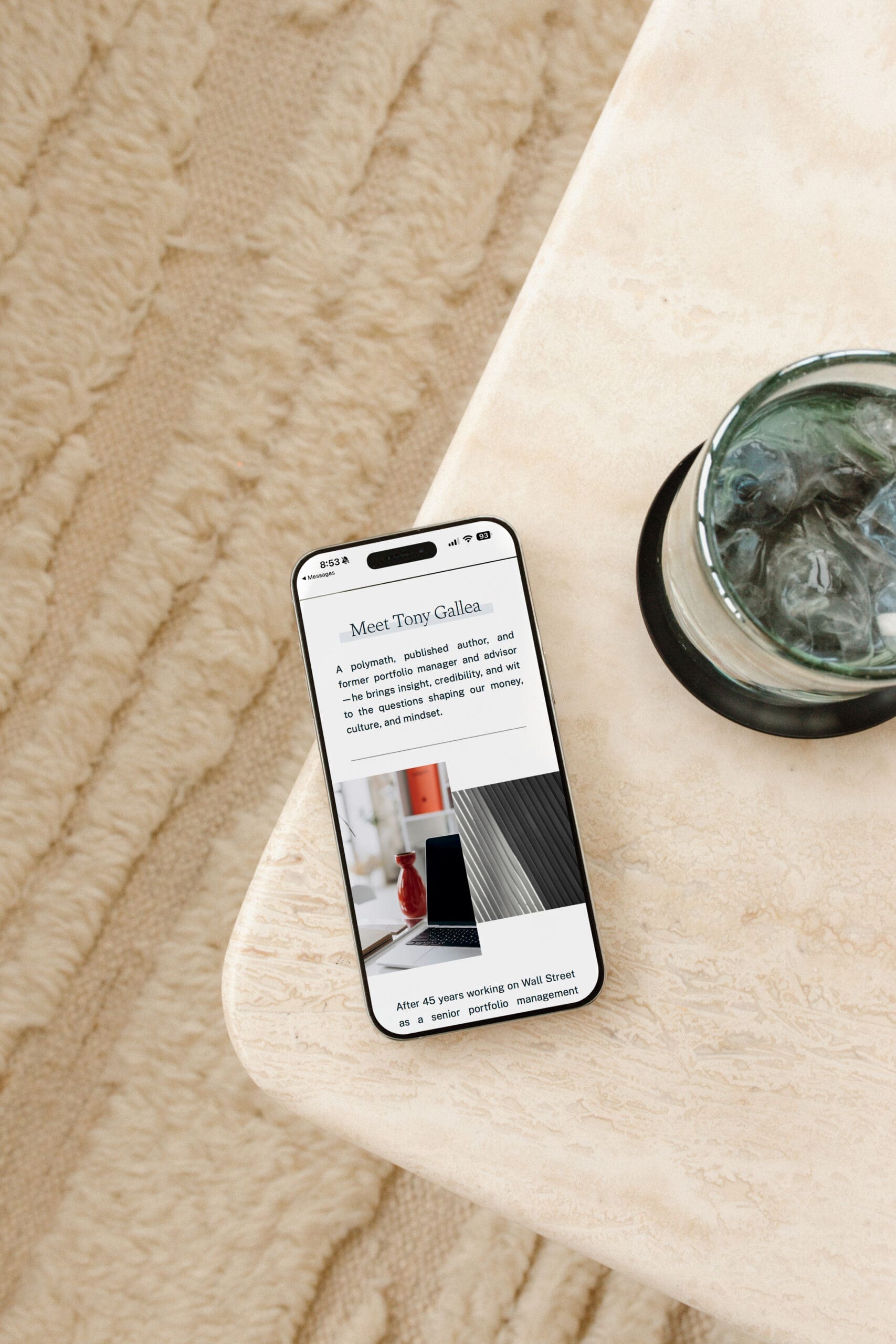 Smartphone on a stone tabletop displaying the Working Profit “About” page, introducing Tony Gallea as a polymath and former portfolio manager—conveying credibility, clarity, and calm sophistication in a personal setting.