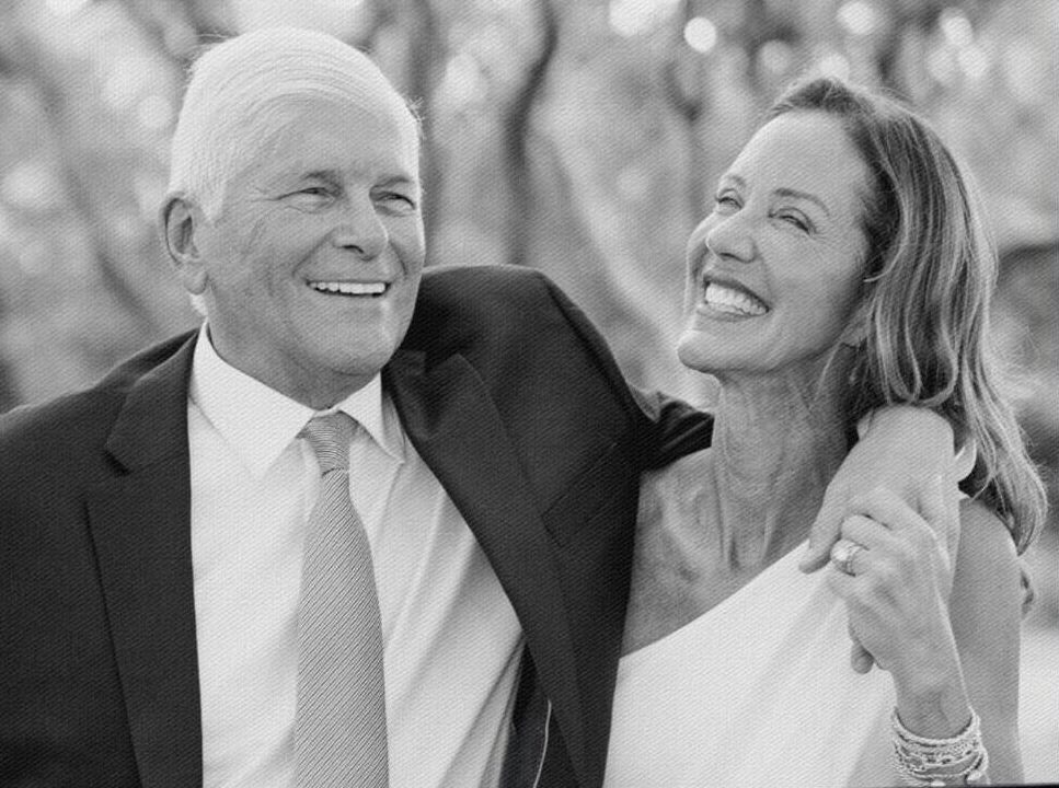 Smiling couple on their wedding day, arm in arm, dressed in formal attire