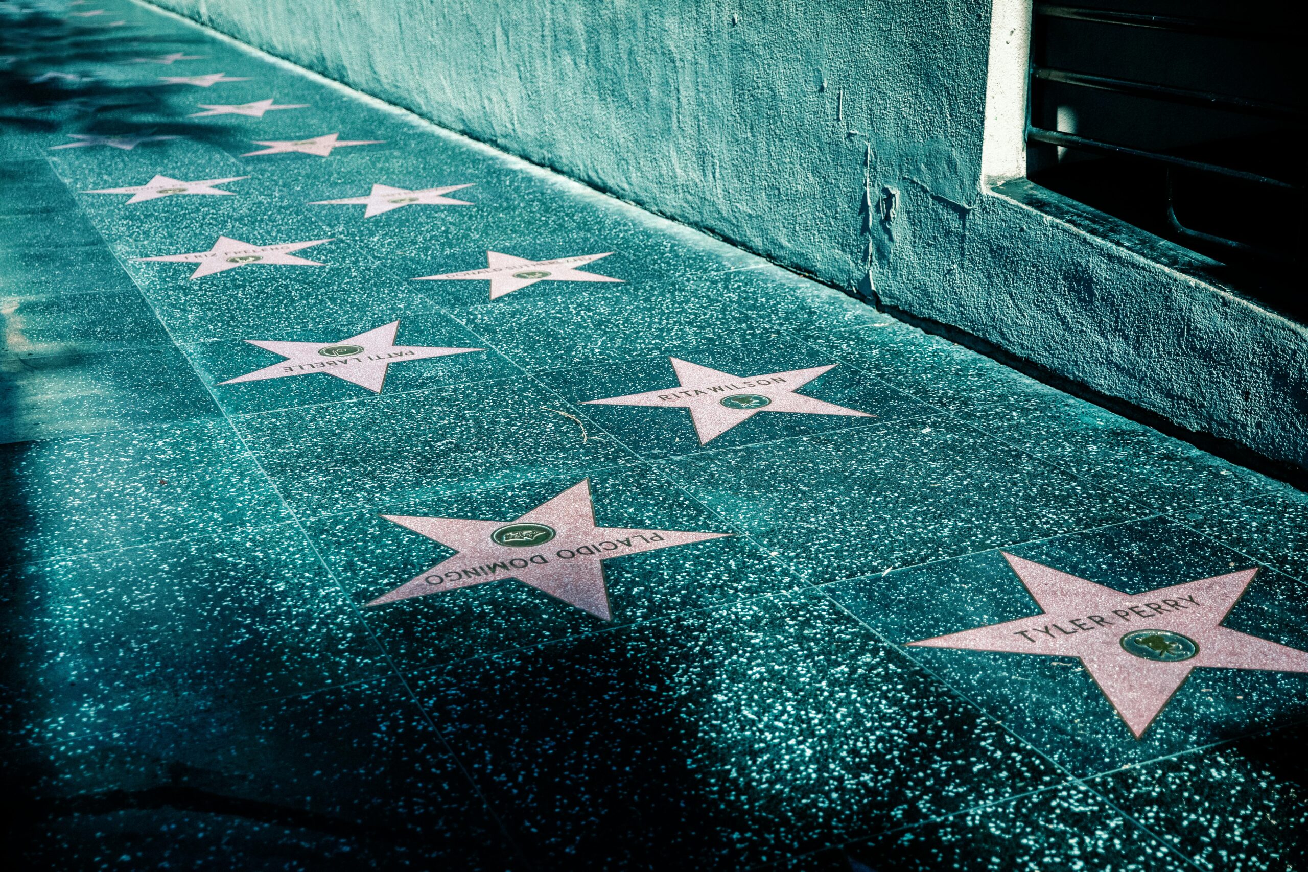 Hollywood Walk of Fame stars displayed along a sidewalk, symbolizing celebrity culture and public attention.