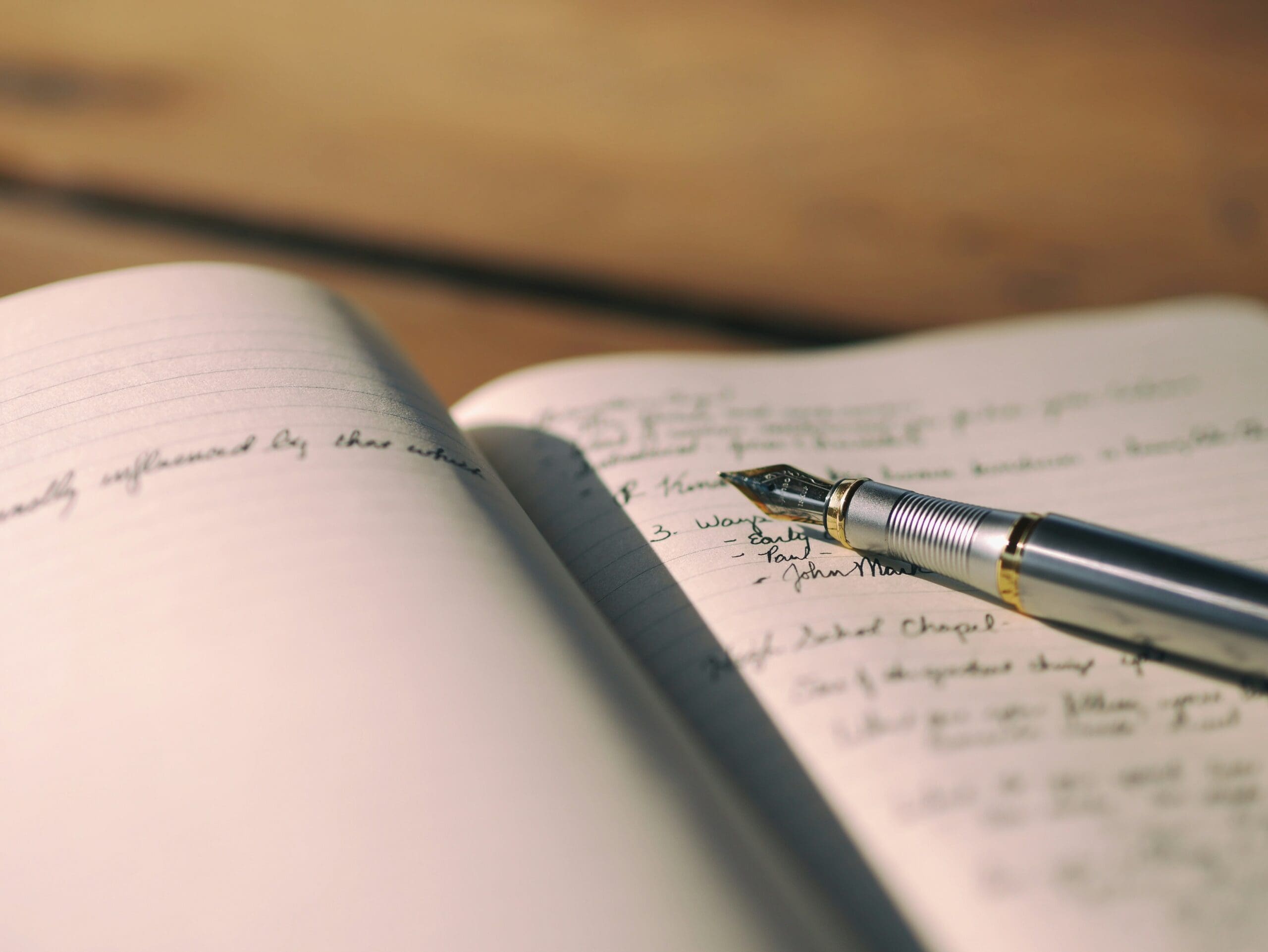 Open notebook with handwritten notes and a fountain pen resting on the pages.